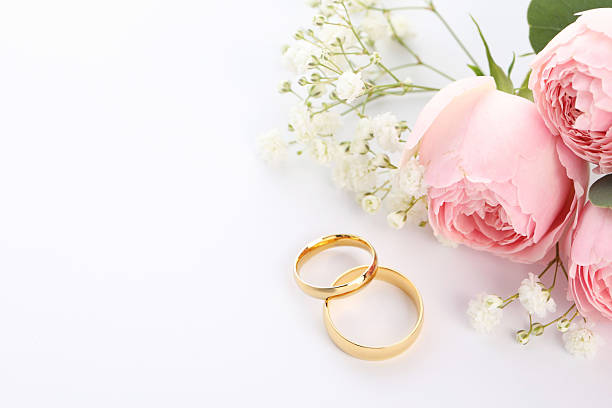 istock Golden wedding rings and flowers on white background. Space for text 2226304852