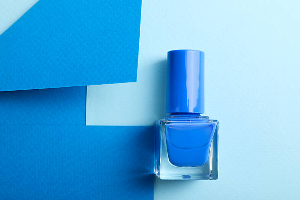 Nail polish in bottle on color background, top view. Space for text