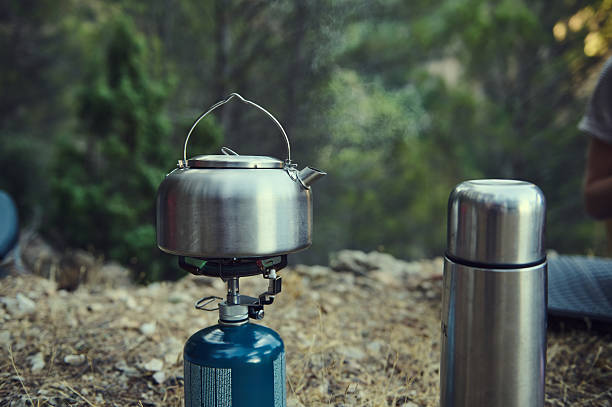 istock Camping Kettle Boiling on Portable Stove Outdoors in a Scenic Forest Setting 2226306947