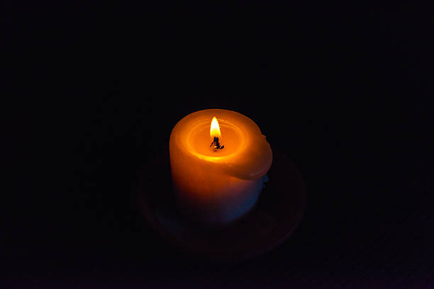 istock A burning candle in the darkness. Selective focus,black background. 2226307112