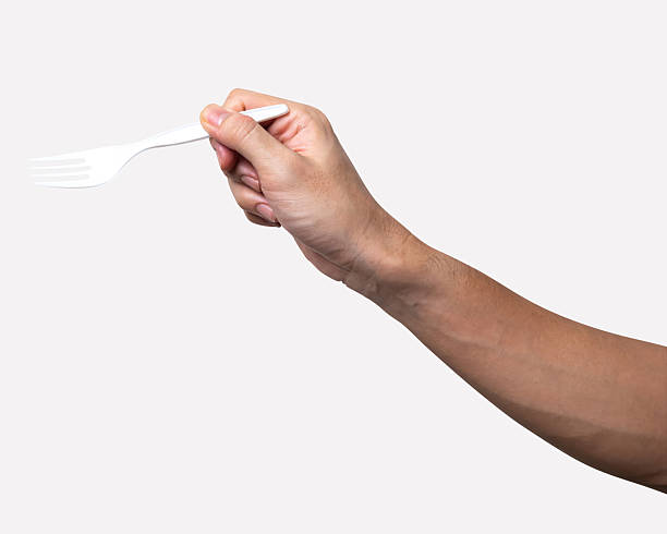 istock Male hand holding a white plastic fork isolated on white background. 2226307631