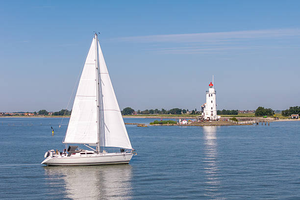 istock Sailboat passing Paard van Marken lighthouse on IJsselmeer 2226313152