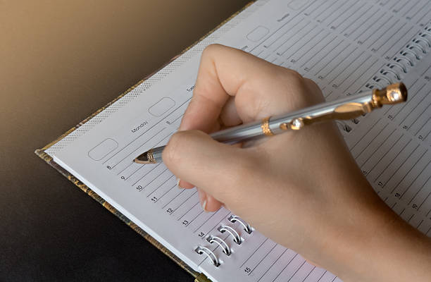 Empty notebook with a pen on a petrol colored background, the word plan is standing on the top of the page, planning new goals, to do list
