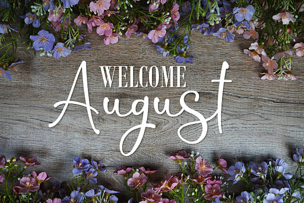 istock Welcome August text with flowers frame on wooden background 2226316310