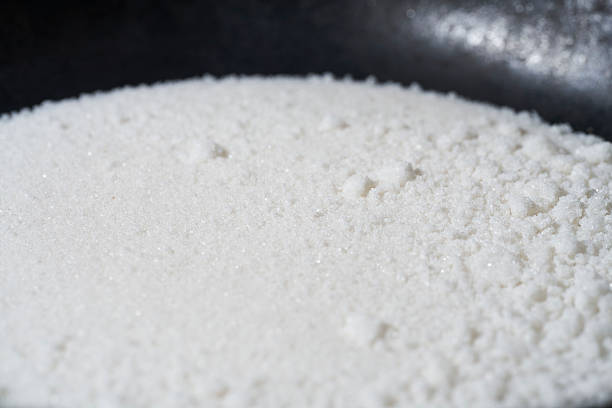 A small mountain of pure white particles emerges from the jet black vessel. Each of these minute crystals quietly catches the light, like a microscopic sand dune or a silent crater. The absolute contrast of black and white strongly stimulates the viewer's imagination. Is it salt, sugar, or an unknown substance? Fragments of everyday life are sublimated into minimalist and powerful abstract art.