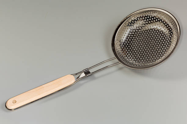 istock Kitchen stainless steel skimmer with wooden handle on gray background 2226325073