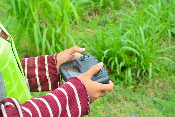 Young Asian woman flying a drone in nature