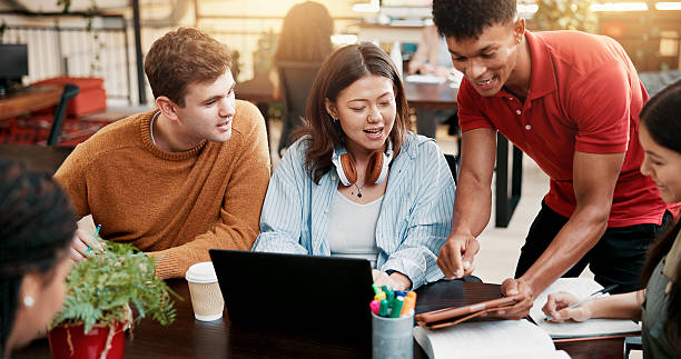 istock Students, tablet and team learning in library for education, help or brainstorming in college. Laptop, happy people and group in university for creative research project, studying or exam discussion 2226329088