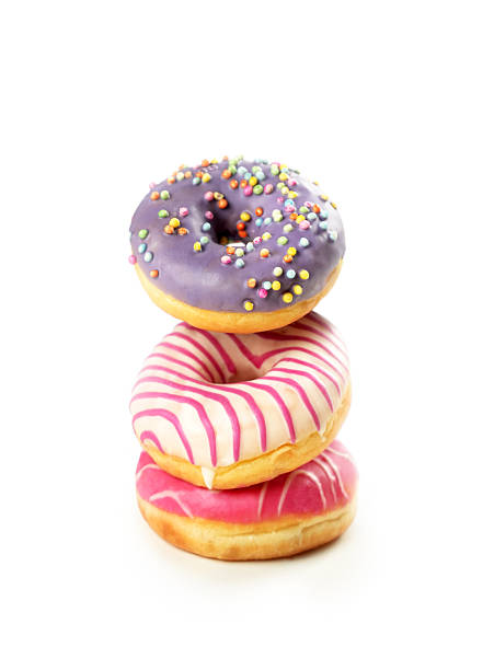 Colorful stacked donuts with sprinkles on a white background creating a delightful dessert display