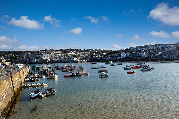 St Ives UK 9th July 2025 \nSt Ives looking beautiful in the sunshine, blue sky, turquoise sea,  boats moored in the harbour, houses on a hill.