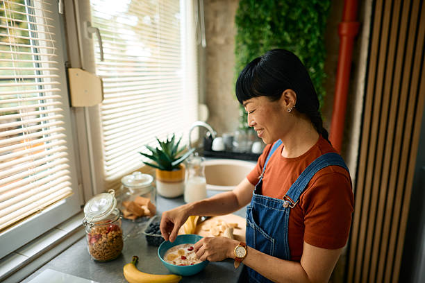 istock Woman preparing healthy breakfast in kitchen with window blinds 2226333436