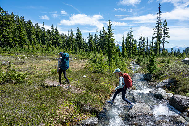 Young girls cross mountain stream