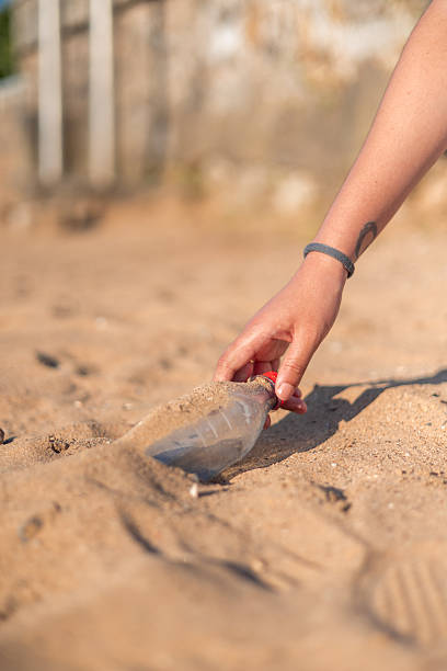 istock Volunteer picking up plastic bottle on the beach 2226336983
