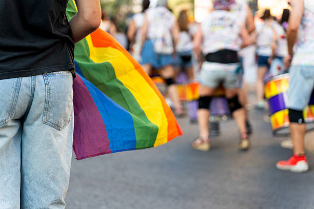 istock Young man holding rainbow flag at lgbt pride parade 2226338577