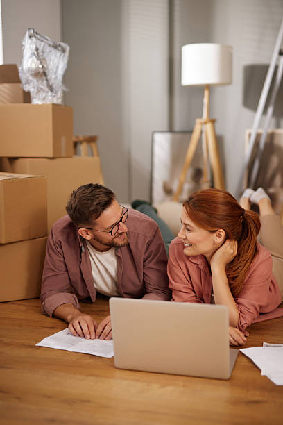 istock Couple lying on floor using laptop and planning in new home 2226345543