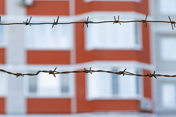 A prison or border fence with barbed wire on the top