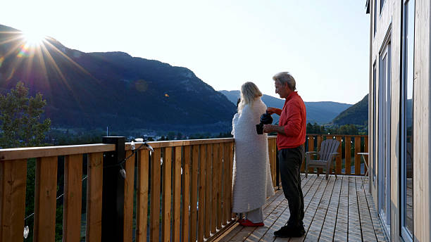 istock Mature couple enjoy tea on cabin deck at sunrise 2226347352