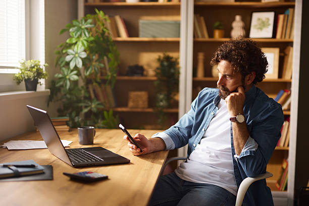 istock Focused freelancer reading messages on smartphone in home office 2226348947