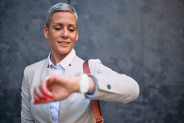 istock Businesswoman checking time on her smartwatch while smiling 2226349363