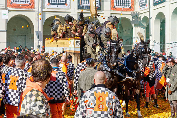Ivrea, Italy - March 02, 2025: groups in traditional dressing take part in the Battle of the Oranges, where a teams of orange handlers on foot throw oranges (representing old weapons and stones) against aranceri of the team \
