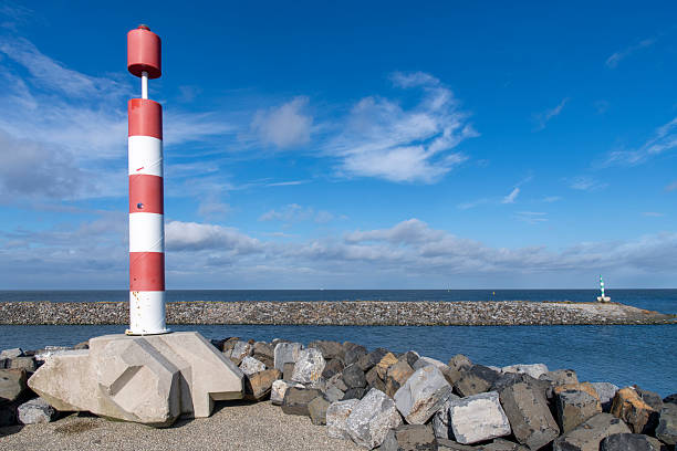 Port of escape on former Breezand working island on Afsluitdijk (dam separates IJsselmeer lake from Wadden Sea), the Netherlands  against a white clouded blue sky