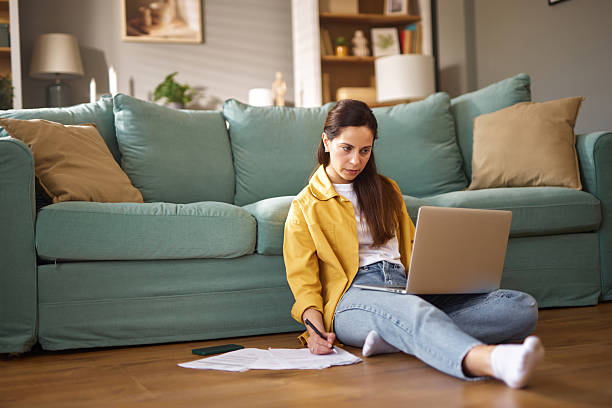 istock Focused woman working from home on laptop and taking notes 2226350277