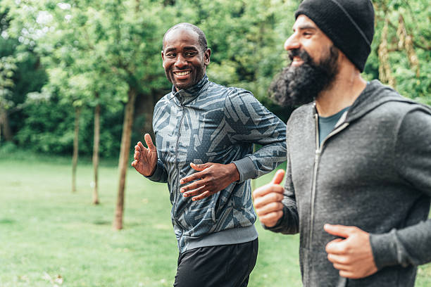 istock Cardio training outdoors. Happy athletes having fun while running together in nature. 2226350625