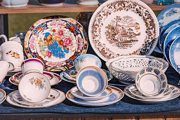 1 June 2025, Belgrade, Serbia: Various antique plates, teacups, saucers and bowls with different decorations displayed on stall at flea market
