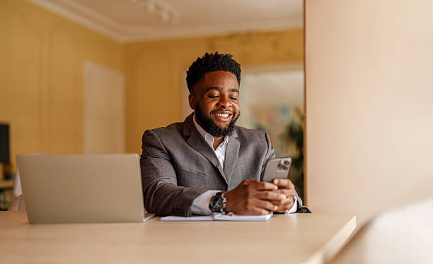 istock Portrait of smiling businessman using online applications over smart phone while working in office 2226353028