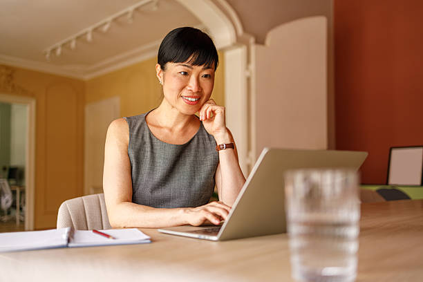 istock Confident female financial advisor examining reports over laptop while working at desk in corporate office 2226353090