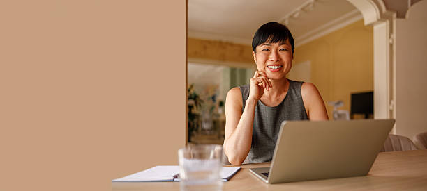 istock Portrait of happy entrepreneur analyzing online data over laptop while working in modern office against wall 2226353139