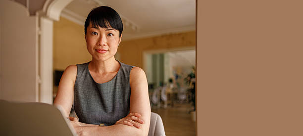 istock Confident businesswoman looking at camera while working over computer at desk in corporate workplace 2226353144