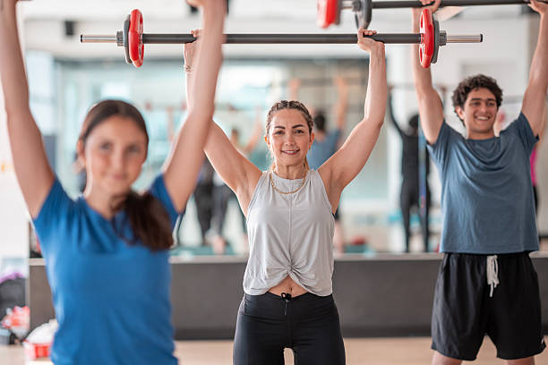 istock Group Fitness Class Lifting Barbells in a Bright Modern Gym Setting 2226353203