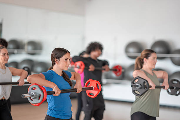 istock Group Fitness Class Performing Weightlifting Exercises in Gym Environment 2226353207