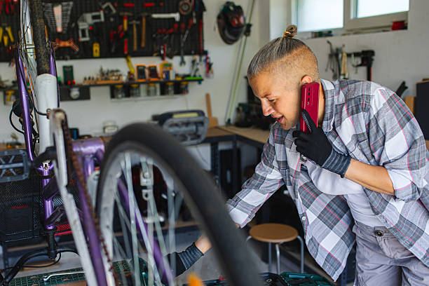 istock Multitasking Woman Repairing Bicycle While Talking on Phone 2226355529
