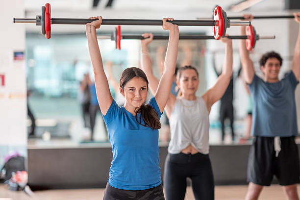 istock Group Fitness Class Performing Weightlifting Exercise in Gym Studio 2226355675