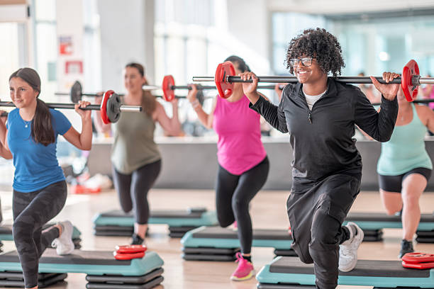 istock Group Fitness Session with Participants Performing Barbell Squats on a Platform 2226355712