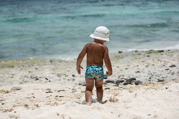 Boy running on a tropical beach with turquoise water