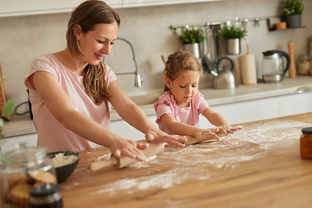 istock Mother and daughter making dough in the kitchen together 2226358238