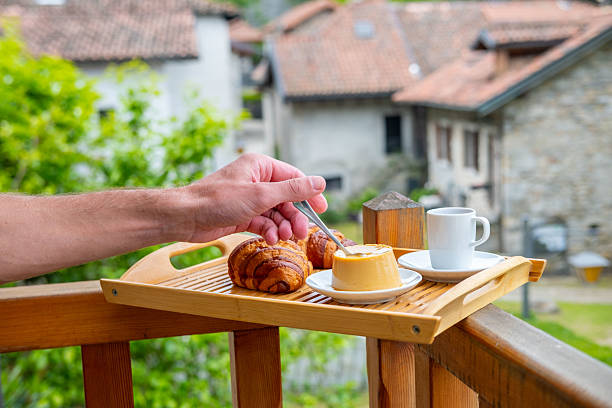 breakfast with creamy pudding panna cotta, fresh croissants, and coffee, Italian Morning, rustic village from balcony, Authentic Italian Charm