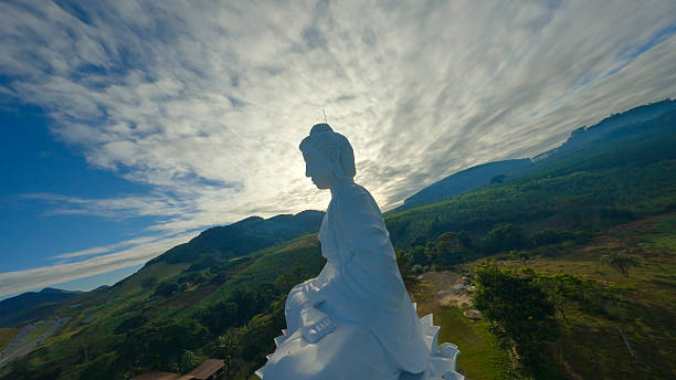 A female adult is clasping both hands, eyes slightly looking up praying at Chinese temple in Ipoh, Perak Malaysia.