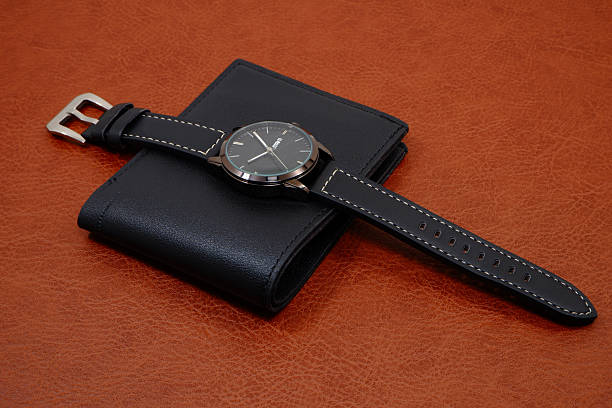 istock Black leather watch on black wallet on brown leather background close-up view 2226361567