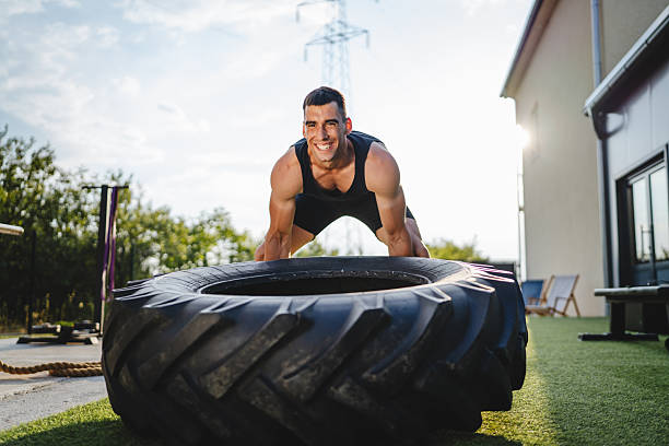 istock fit caucasian athlete man exercising outdoors, lifting heavy tyre 2226365829