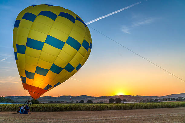 Hot air balloon fully inflated after landing on field