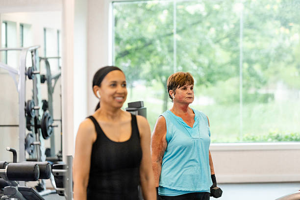 istock Two Women Exercising Together in a Modern Gym 2226367867