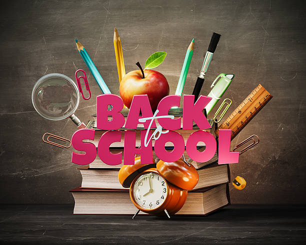 School accessories with books and Back To School text on blackboard background.