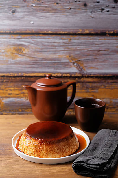 Caramel custard flan in the plate on a wood background