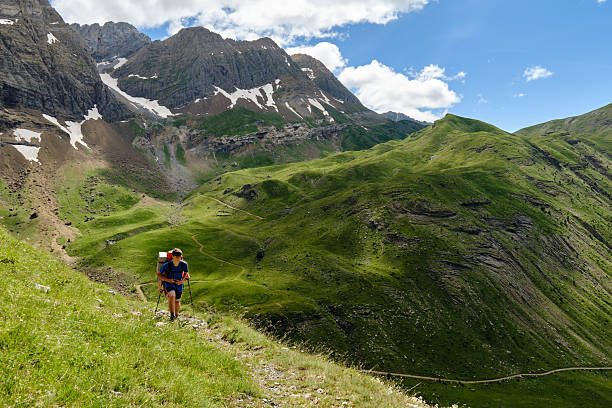 istock Hikers backpacking up a hill with mountains in the background. 2226369519