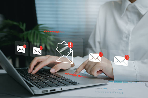 istock Email communication alert concept. Woman checking new email notifications on laptop, digital inbox with red badge icons. 2226369527