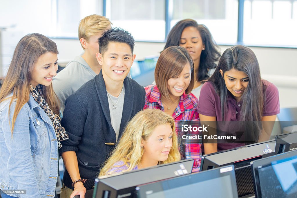 Group Of Students Collaborating On Computer Tasks In A Bright Classroom ...